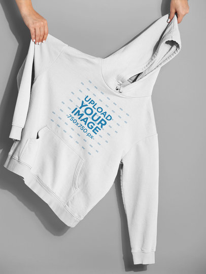 Pullover Hoodie Mockup Being Held Against a Plain Surface