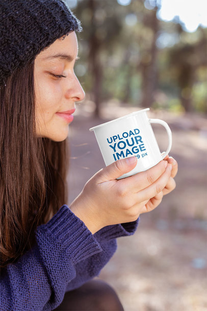 Mockup of a Young Woman Holding a 12 oz Enamel Mug in the Woods