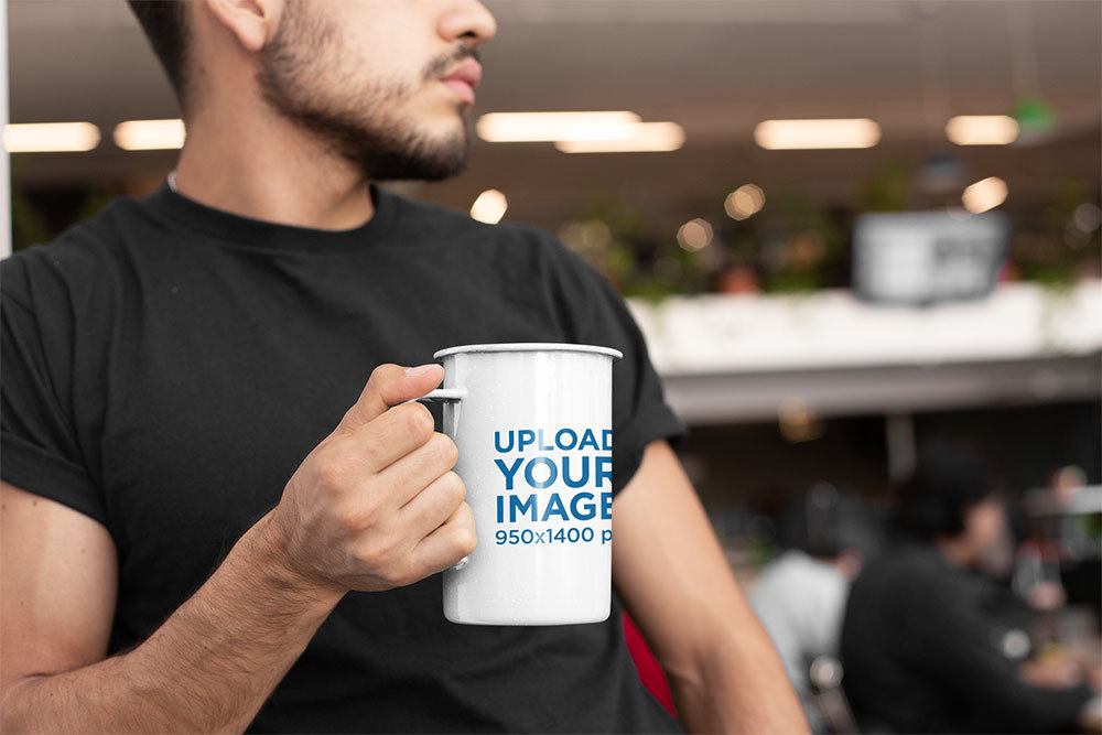 Mockup of a 21 Oz Enamel Mug Held by a Young Man 