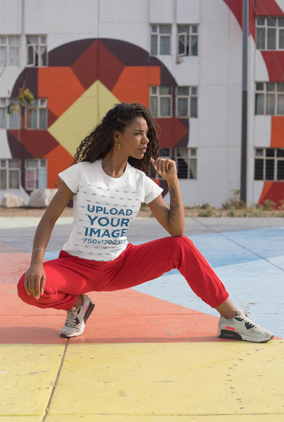 Tee Mockup of a Sporty Woman Posing in a Colorful Urban Scenario