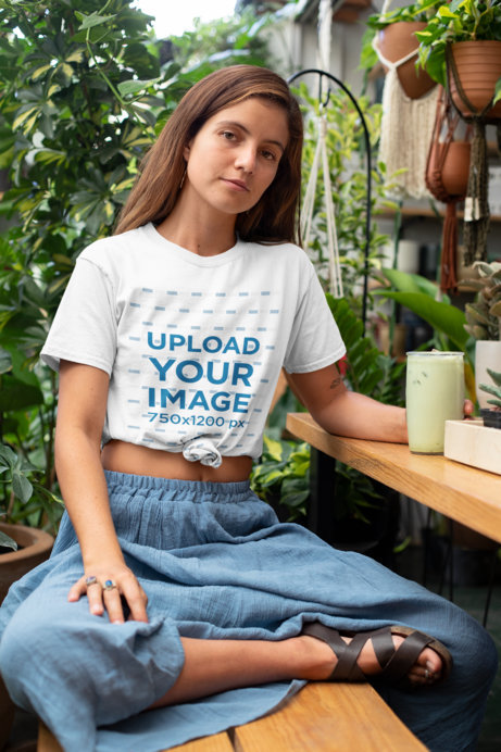 Knotted T-Shirt Mockup of a Woman at an Outdoor Restaurant