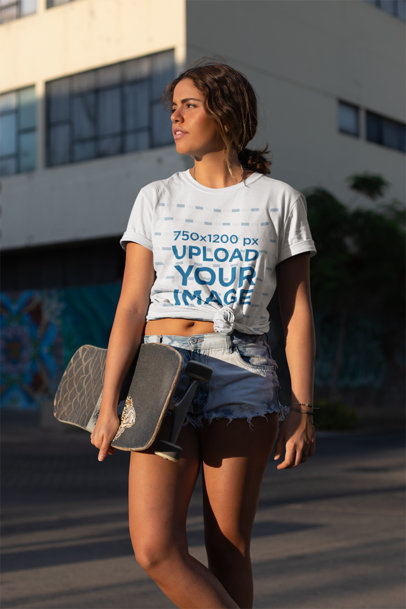 Mockup of a Young Woman with a Skateboard Wearing a Knotted T-Shirt