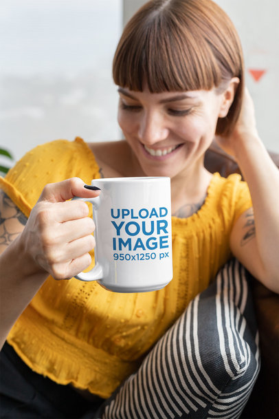 15 Oz Coffee Mug Mockup Featuring a Tattooed Woman Sitting on a Couch