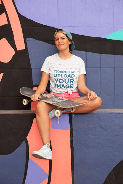 Knotted Tee Mockup of a Skater Woman Sitting in Front of an Urban Mural