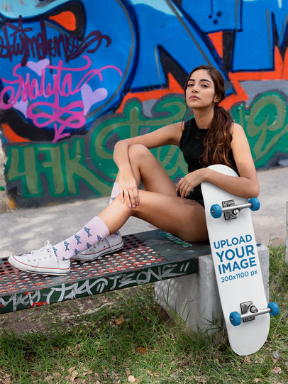 Skateboard Mockup Featuring a Daring Woman in Front of a Graffiti Wall