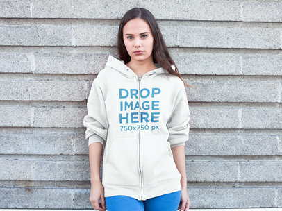Clothing Mockup of a Woman in a Hoodie Against a Wall