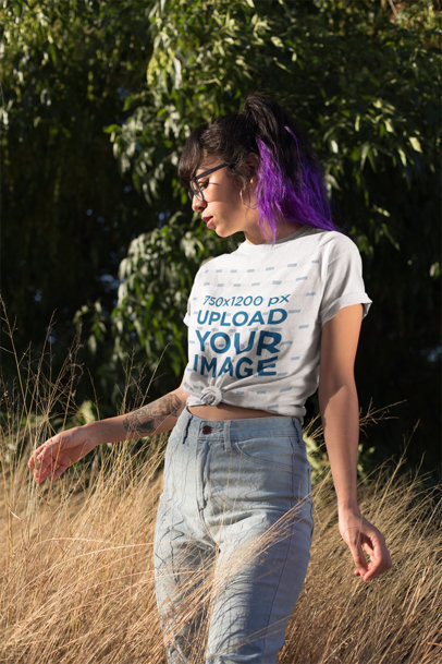 Knotted T-Shirt Mockup of a Woman Posing Between Pasture at Sunset