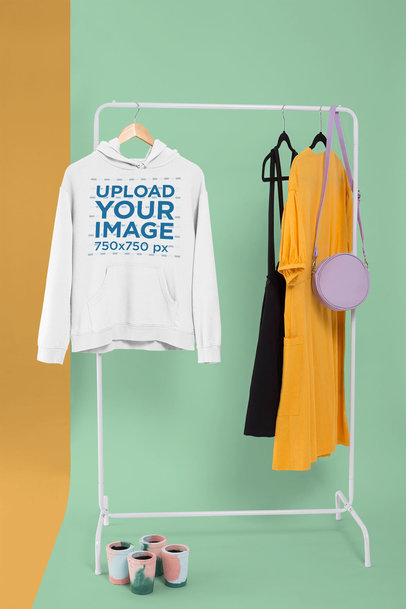 Pullover Hoodie Mockup Hanged from a Rack Along with Casual Dresses 26734