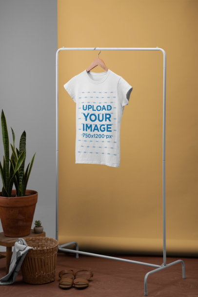 Women's T-Shirt Mockup Hanged from a Rack Next to a Plant Pot and a Basket