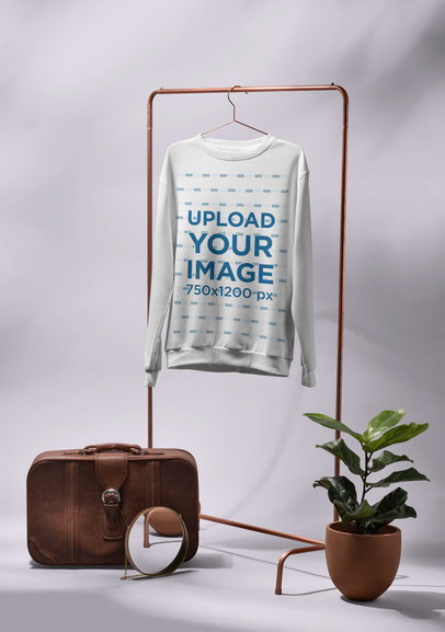 Mockup of a Men's Crewneck Sweatshirt Hanged Next to a Vintage Suitcase