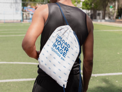 Drawstring Bag Mockup Featuring a Man on a Soccer Field Facing Backward 27581