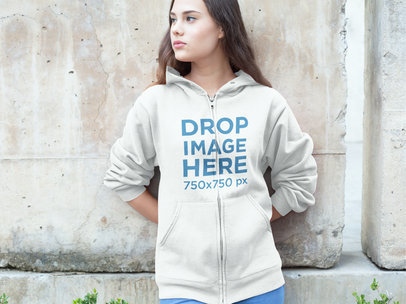 Woman Leaning Against a Cement Wall Hoodie Mockup 