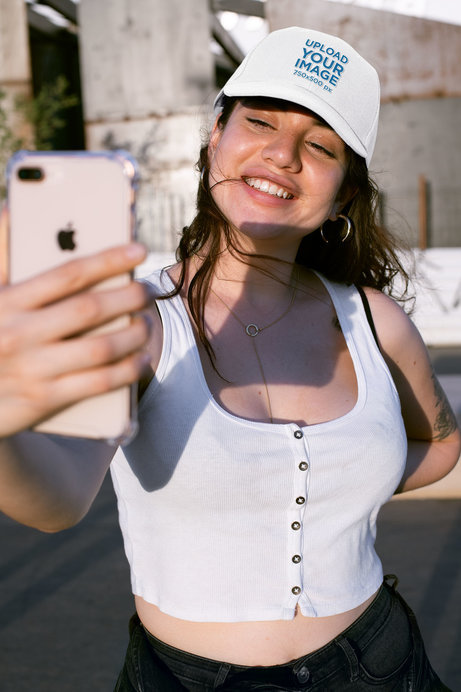 Mockup of a Smiling Woman Taking a Selfie with Her Hat On
