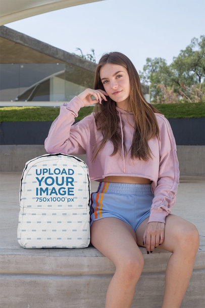 Backpack Mockup Featuring a Teenager Sitting on Concrete Floor