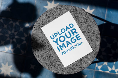 Mockup of a Postcard on a Round Marble Table