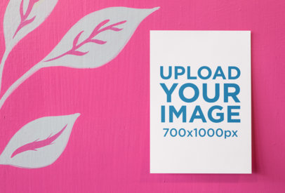 Mockup of an A6 Postcard Lying on a Vibrant Pink Surface with Painted Leaves