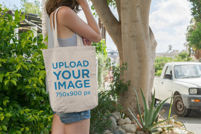 Tote Bag Mockup Featuring a Woman with Denim Shorts Against a Tree 11-el