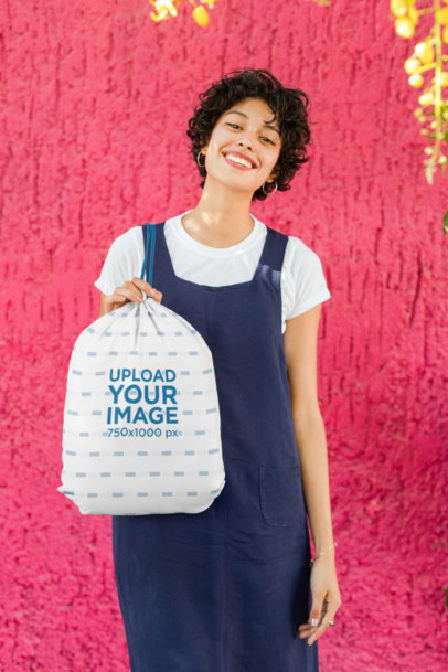 Drawstring Bag Mockup Featuring a Smiling Woman Against a Bright Wall 27585