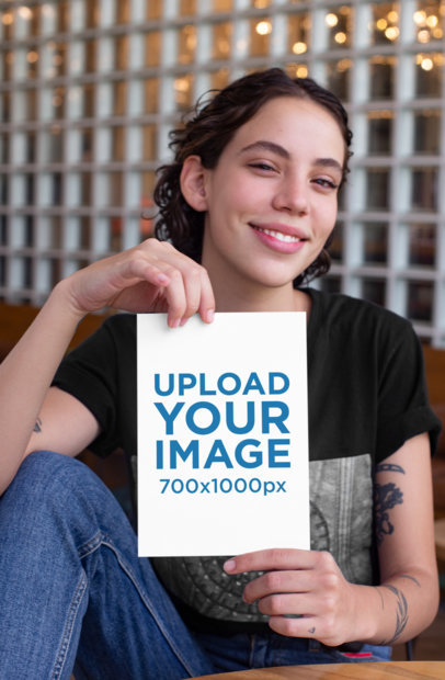 Mockup of a Smiling Tattooed Woman Showing an A4 Flyer