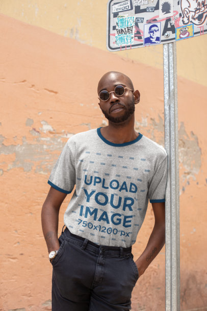 Ringer T-Shirt Mockup of a Man Leaning Against a Post