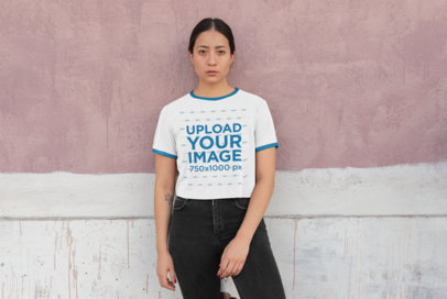 Mockup of a Woman with a Ringer Tee Leaning Against a Paint-Dripping Wall