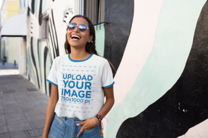 Ringer T-Shirt Mockup Featuring a Happy Woman in Front of a Street Art Mural 