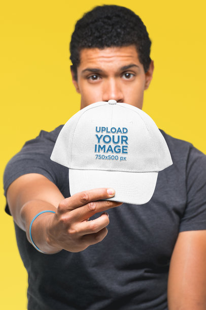 Mockup of a Man Showing off His Dad Hat in a Studio
