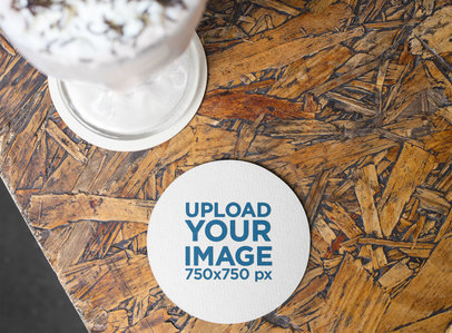 Mockup of a Round Coaster on a Wooden Surface near a Milkshake