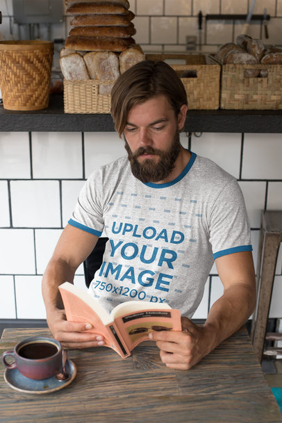 Ringer Tee Mockup Featuring a Hipster Man Reading at a Bakery