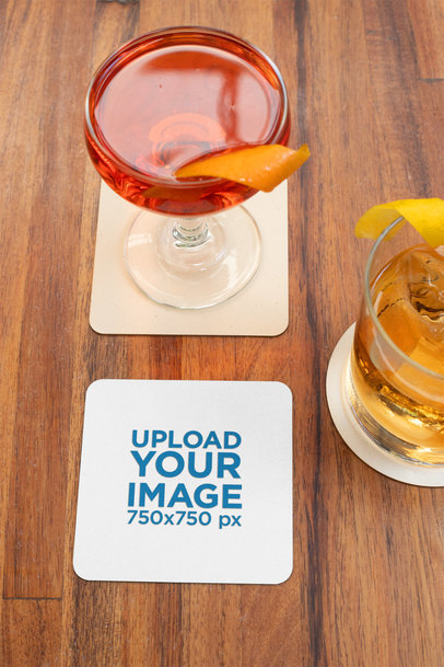 Squared Coaster Mockup Placed over a Wooden Surface by Some Cocktails