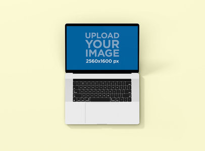 Mockup of a MacBook Pro Resting on a Colored Surface