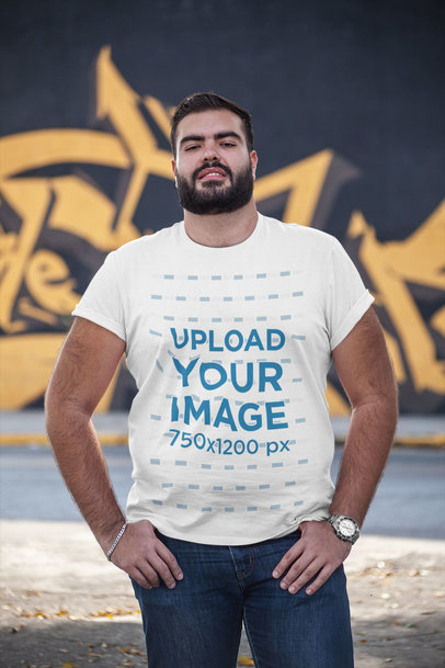 Plus Size T-Shirt Mockup of a Bearded Man Posing in the Street with a Graffiti Wall on the Background 