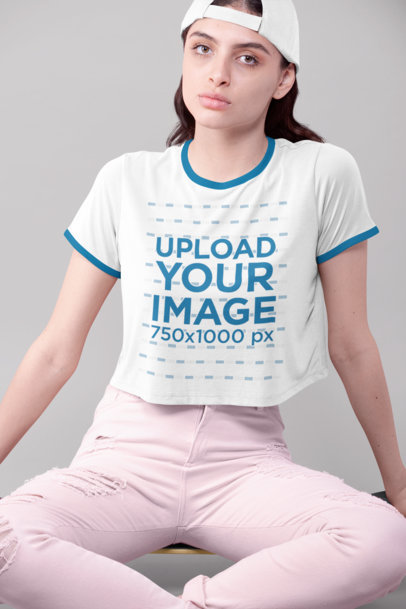 Crop Top Ringer Tee Mockup Featuring a Woman Sitting in a Studio