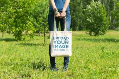 Mockup of a Woman Holding a Tote Bag at an Open Field 24-el