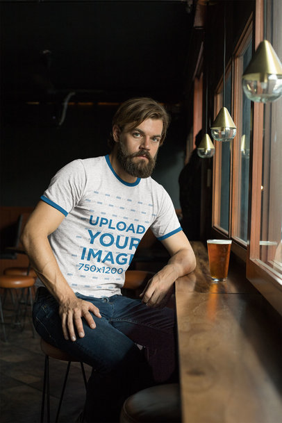 Heather Ringer Tee Mockup of a Man Drinking a Beer in a Bar 