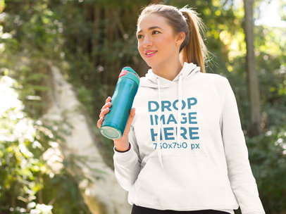 Young Woman at a Park Drinking Water Hoodie Mockup