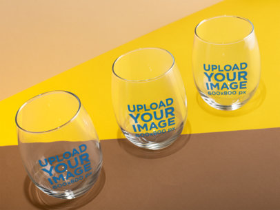 Mockup of Three Stemless Wine Glasses with a Colorful Background