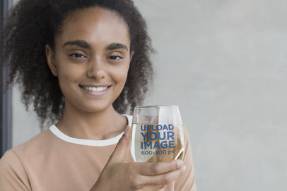 Mockup of a Smiling Woman Holding a Stemless Wine Glass 27951