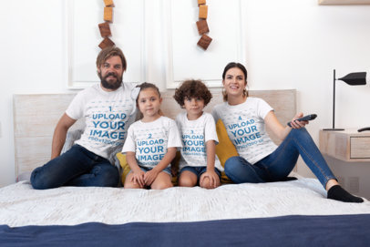T-Shirt Mockup of a Family of Four Watching TV on a Bed