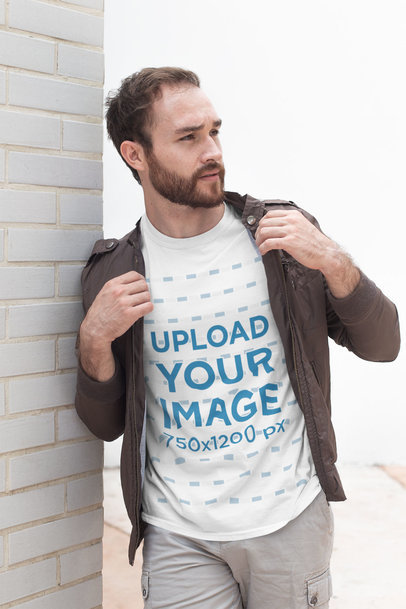 Shirt Mockup of a Bearded Man Leaning Against a White Brick Wall