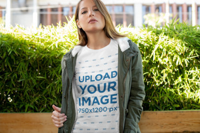 T-Shirt Mockup of a Young Woman with Bushes in the Background