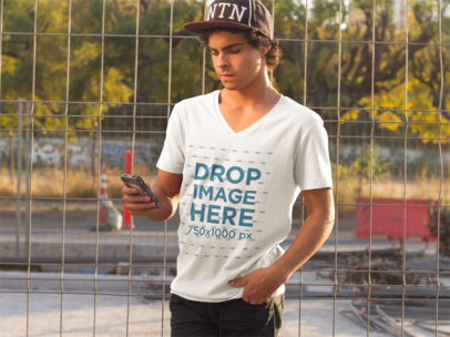 Guy at a Skate Park Using an iPhone T-Shirt Mockup a8941