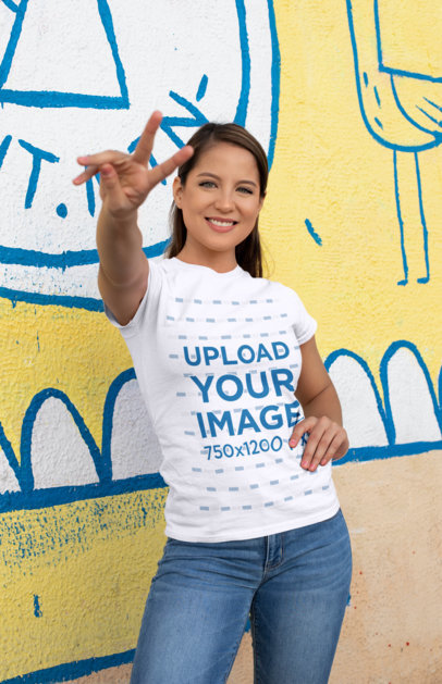 Shirt Mockup of a Woman Doing the Peace Sign Against a Street Art Wall 