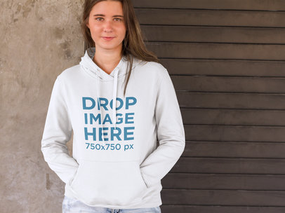 Woman Standing in Front of a Concrete Wall Hoodie Mockup