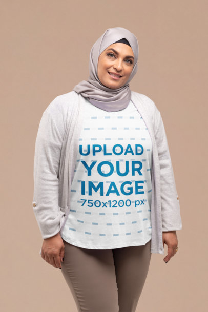 T-Shirt Mockup of a Smiling Woman with a Hijab Posing at a Studio 