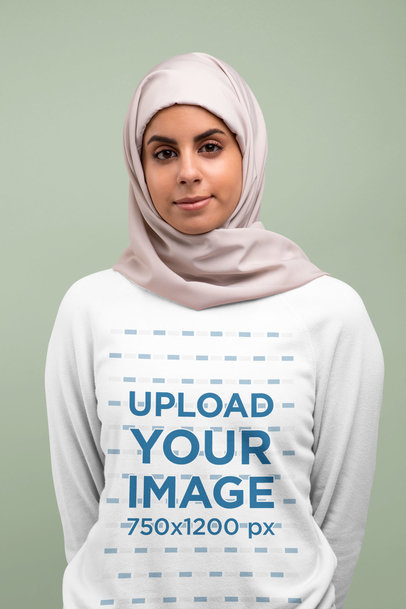 Crewneck Sweatshirt Mockup Featuring a Woman With a Hijab Against a Solid Color Backdrop 