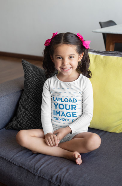 Long Sleeve T-Shirt Mockup Featuring a Girl Sitting on a Couch 