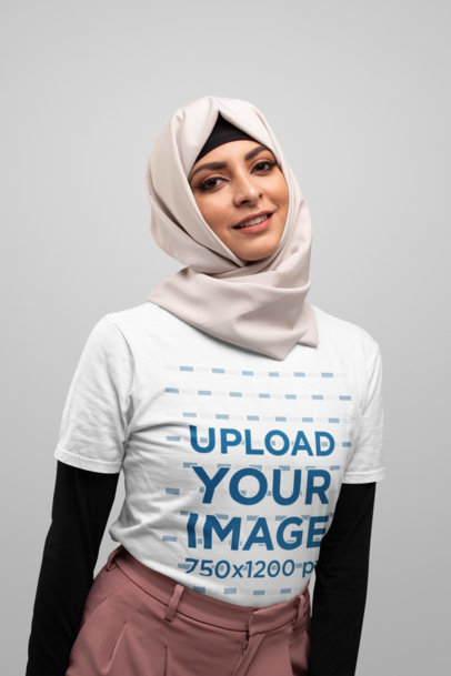 T-Shirt Mockup of a Woman Wearing a Hijab with a Plain Background