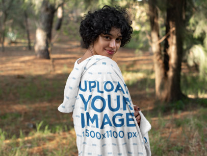 Mockup of a Woman in the Woods Covering Herself with a Hooded Blanket 28134