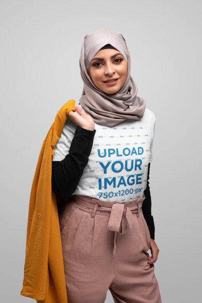 T-Shirt Mockup Featuring a Woman with a Hijab Carrying a Coat over Her Shoulder 28288